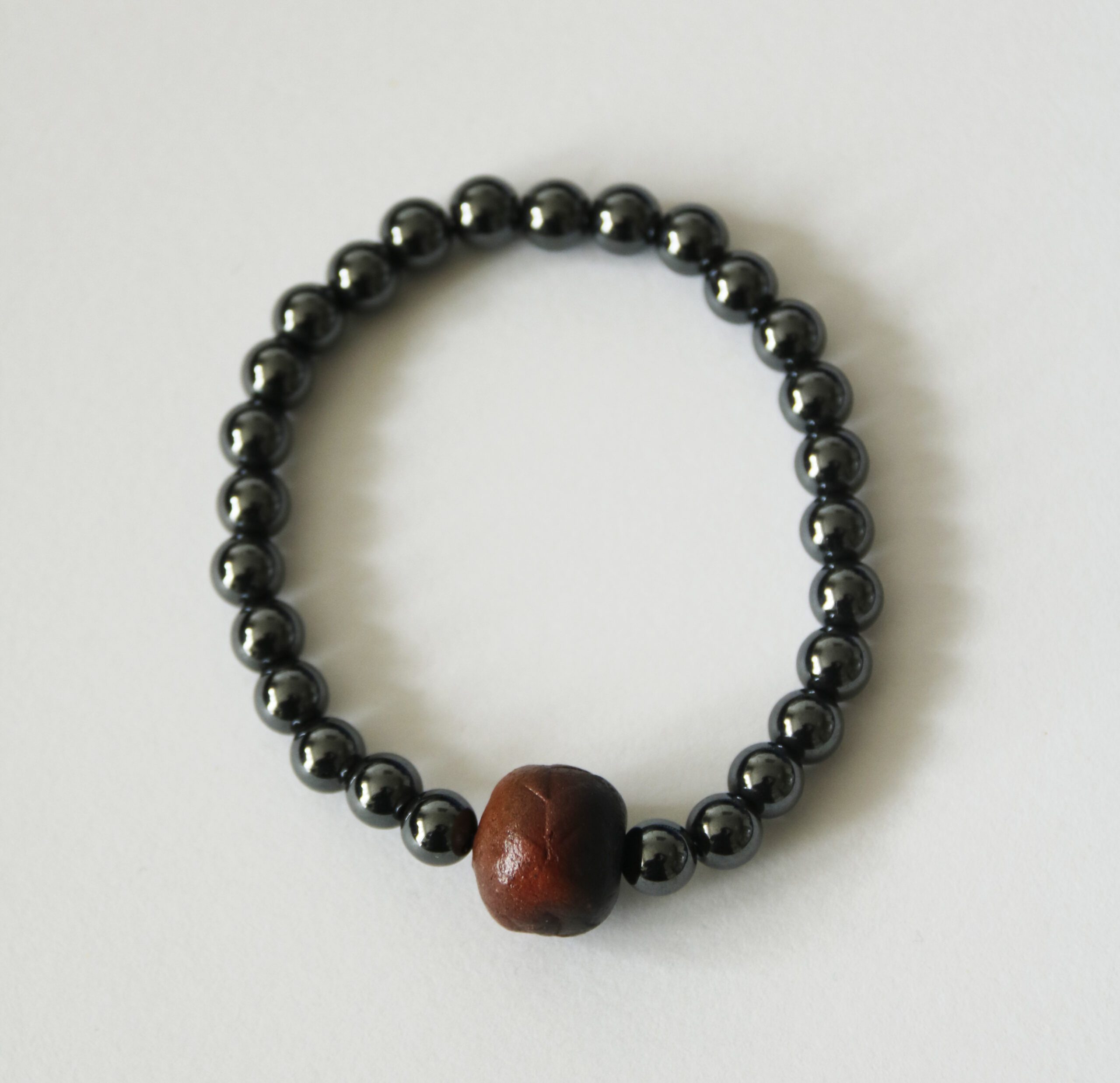 Náramek z minerálů a ručně vyráběného keramického korálku vypalovaného v ohni.